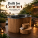 Wooden hot tub with steps on a wooden deck with scenic background. Built for Comfort
