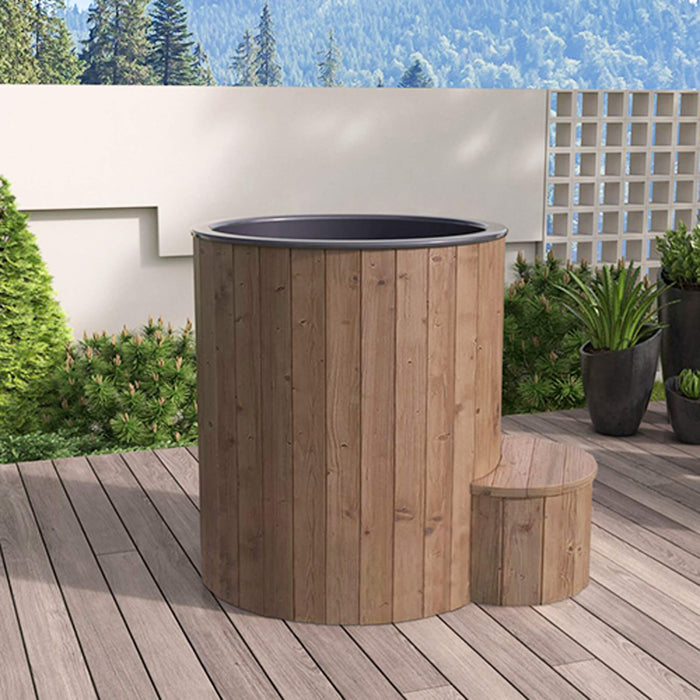 Wooden hot tub on a wooden deck with a garden and mountains in the background