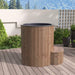 Wooden hot tub on a wooden deck with a garden and mountains in the background